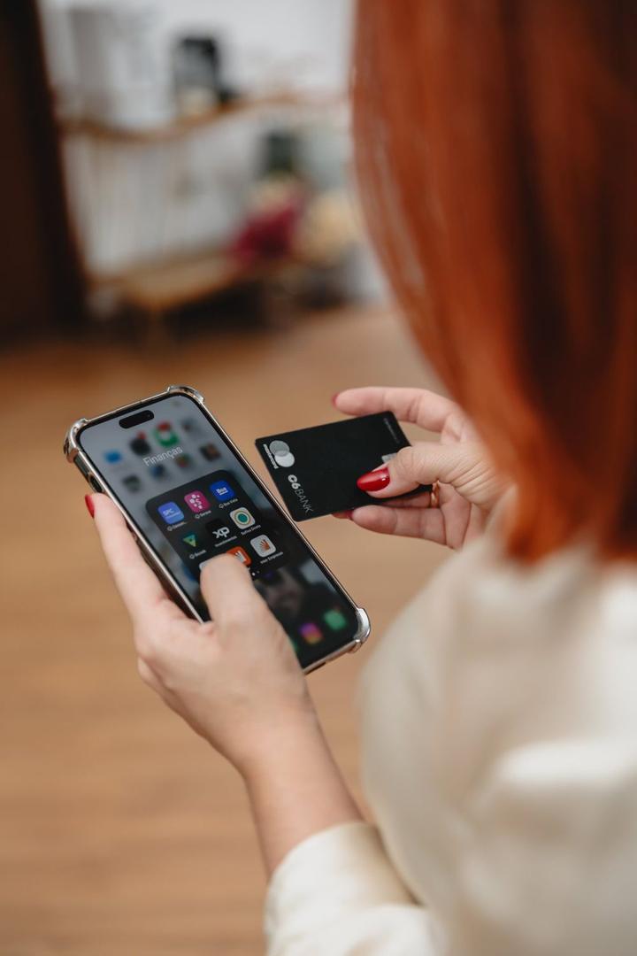 Mãos segurando celular e cartão