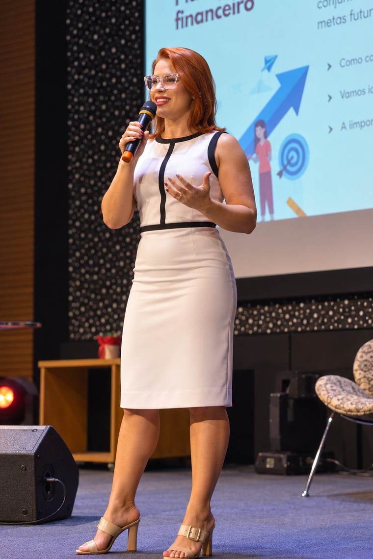 Jéssica Fontoura palestrando no palco, com microfone na mão